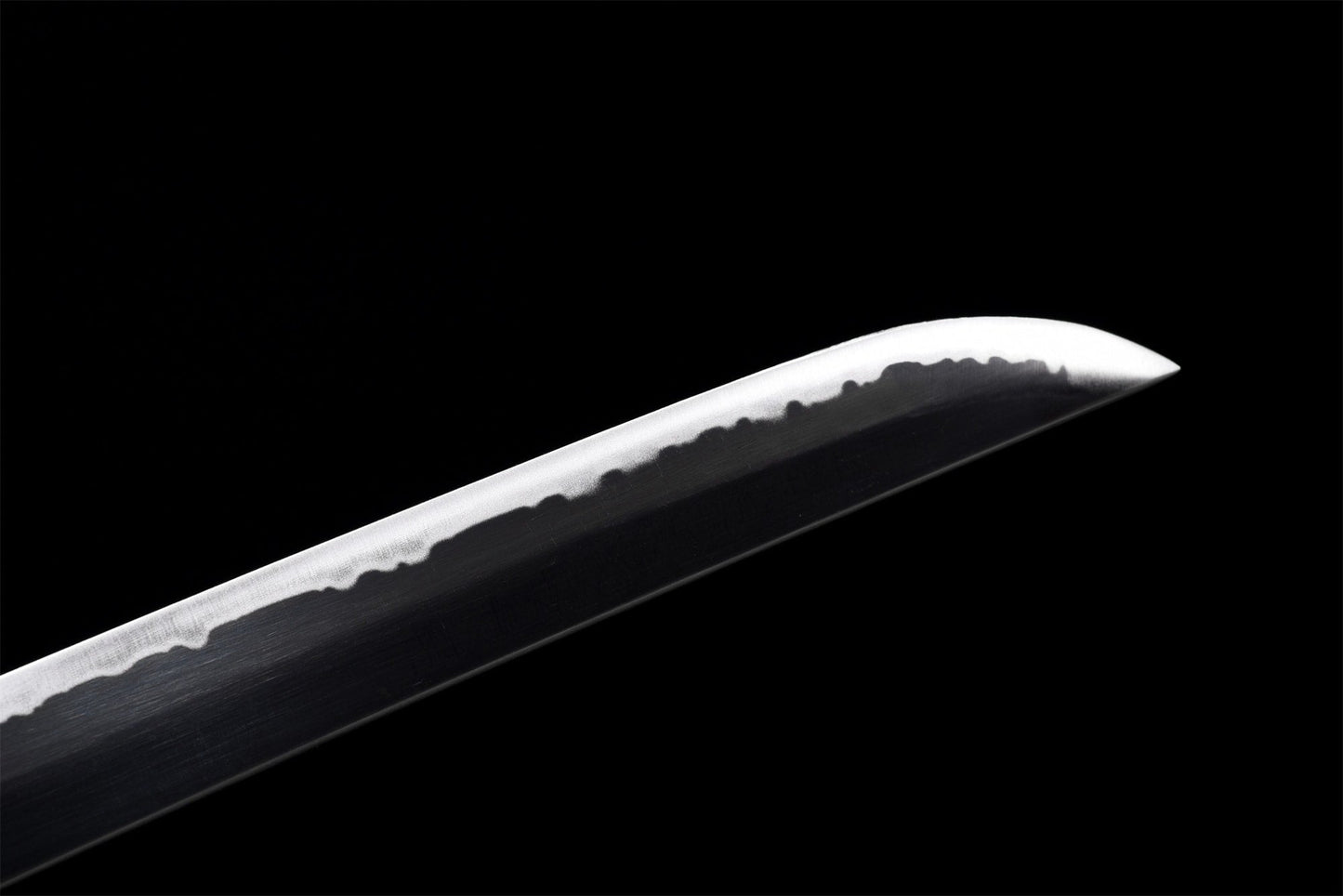 Close-up of the carbon steel blade tip – handmade finish and hamon line visible