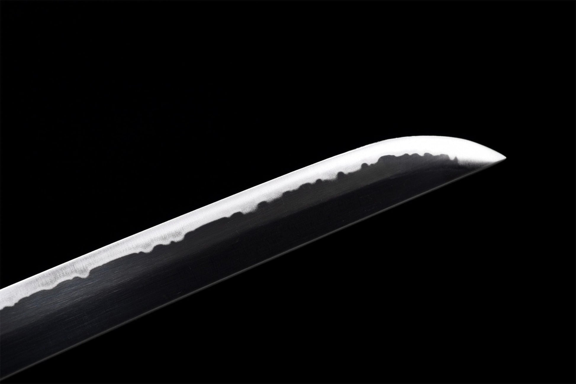 Close-up of the carbon steel blade tip – handmade finish and hamon line visible